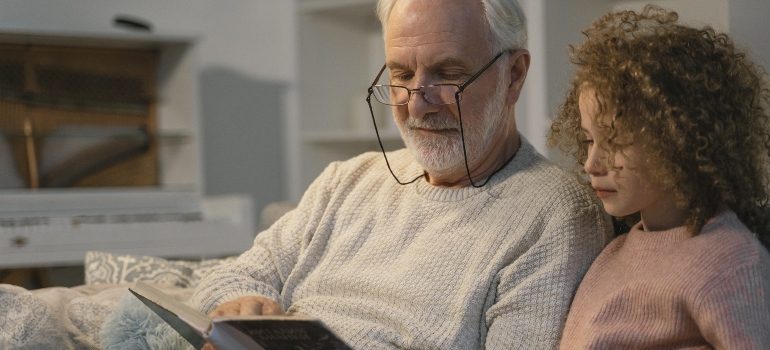a grandfather reading to his granddaughter