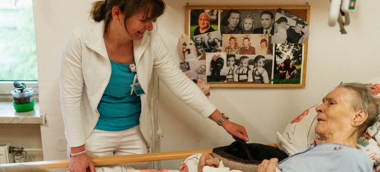 a nurse standing next to the patient’s bed