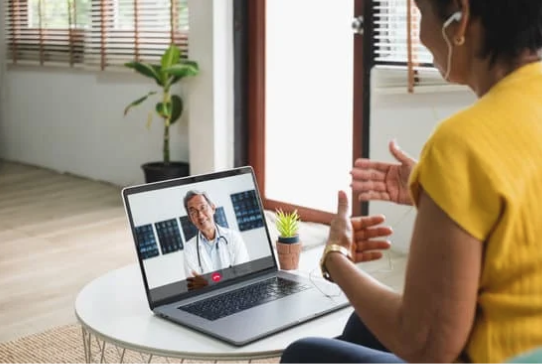 women talking to doctor on laptop